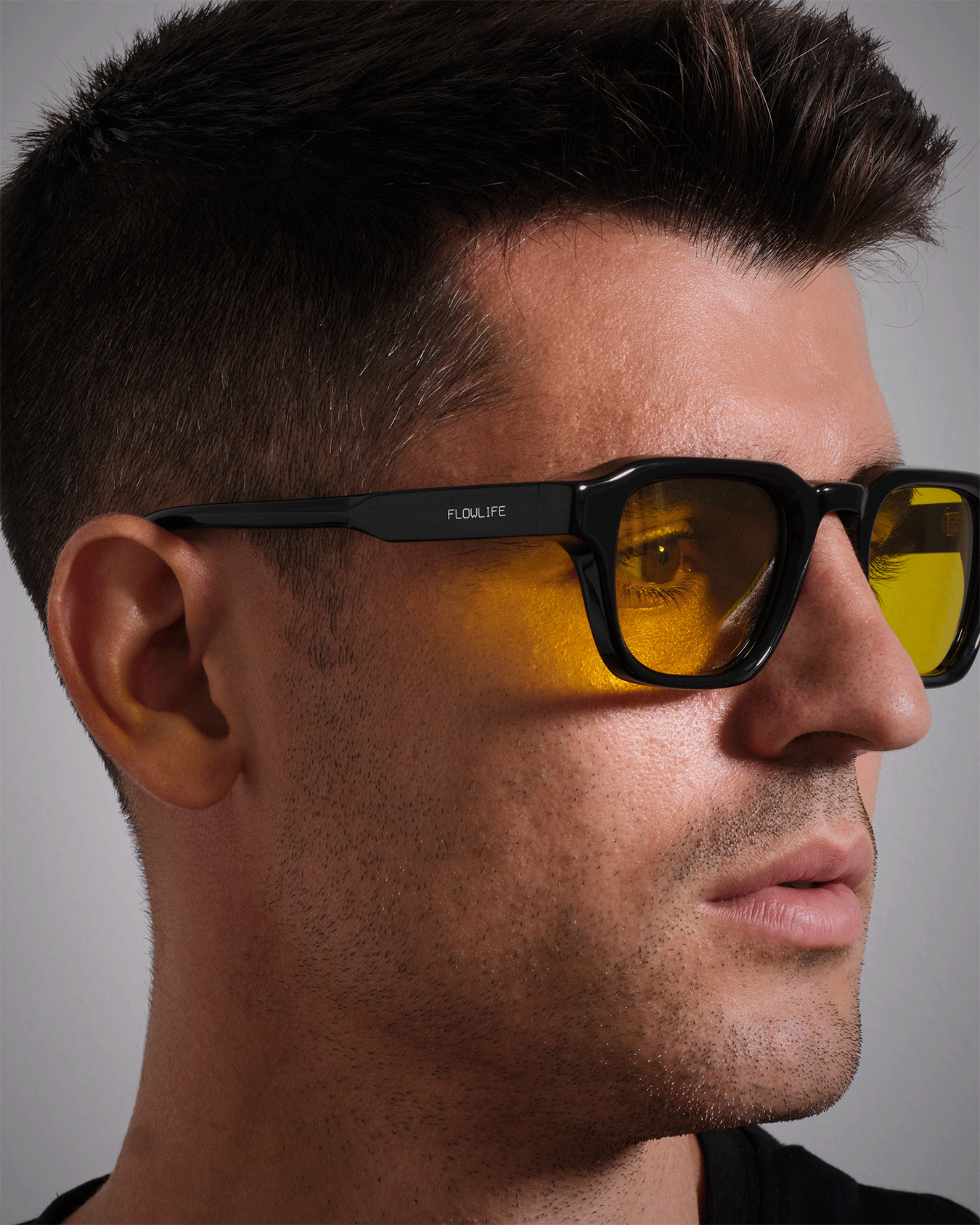 Närbild i profil av Álvaro Morata som bär Flowglasses Day Sync 03 - Álvaro Edition med bärnstensfärgade linser och svart båge