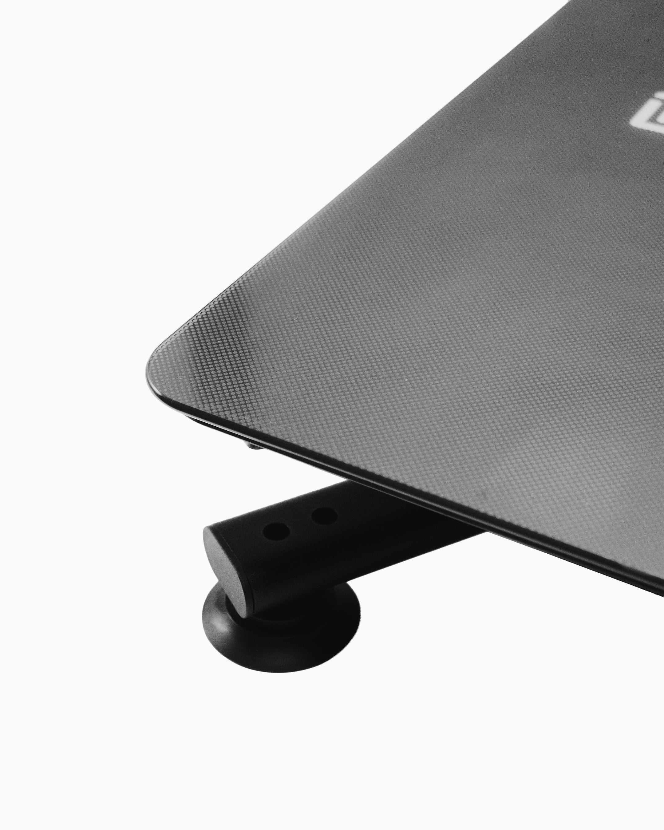 Close-up of the Flowplate Vibe Pro corner showing the textured black platform and a support foot.